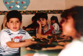 A picture of me as a kid looking very bored in a classroom.